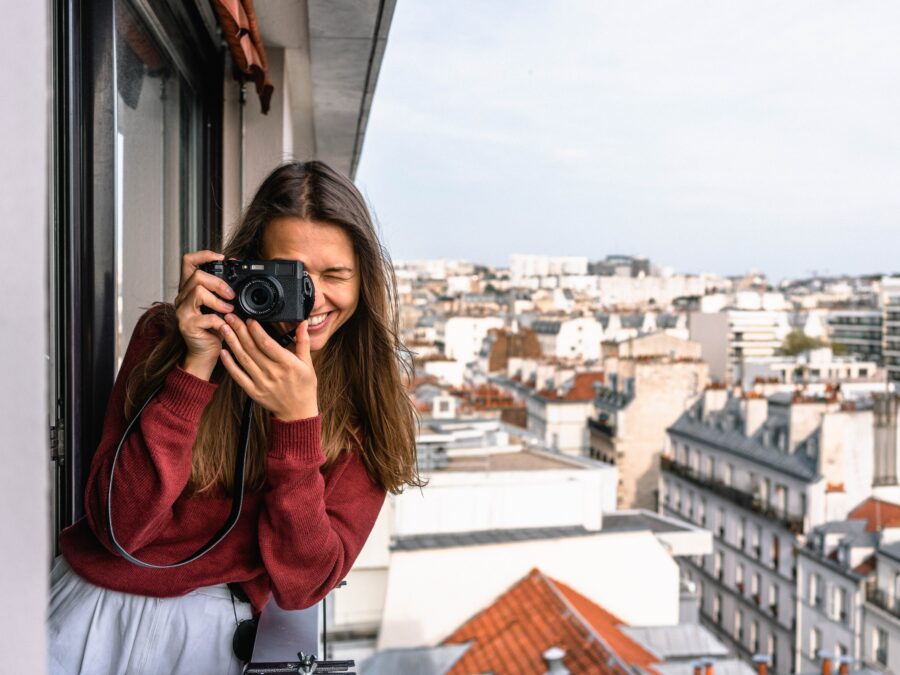 Mujer haciendo una foto desde un balcón en España