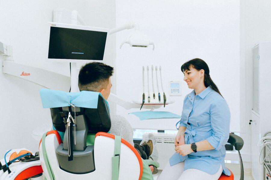 A dentist discusses easy access to the Spanish healthcare system with a patient as a foreigner.