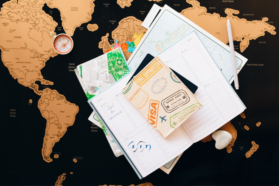 Un pasaporte encima de documentos y un mapa.
